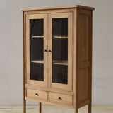 Wooden cabinet with glass doors on a plain background