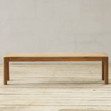 Wooden bench on a wooden floor with a plain wall background