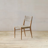 Wooden chair with woven pandan seat and backrest on a wooden floor against a white wall