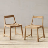 Two wooden chairs on a wooden floor with a plain background