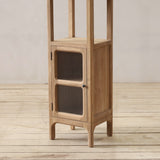 Wooden cabinet with glass doors on a wooden floor against a plain wall