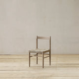 Wooden chair with woven seat on a wooden floor against a beige wall