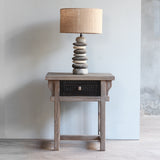 Front view LUNAR Rattan End Table with Pebbles Lamp on top of it.
