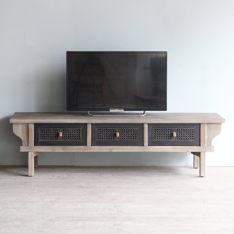 LUNAR Rattan TV Cabinet with a TV on top.