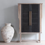 Front view of LUNAR Rattan Tall Cabinet with an earthenware vase next to it.