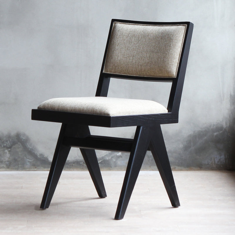 3/4 view of Torino Chair in black wood frame and tan fabric with upholstered backrest.