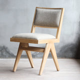 3/4 view of Torino Chair in natural wood frame and tan fabric with upholstered backrest.