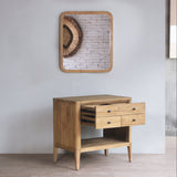 Wooden side table with drawers against a white wall