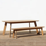 Outdoor wooden dining table and bench set on a wooden floor.