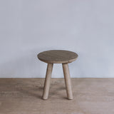 Reclaimed pine wood end table on a wooden floor with a plain white wall background
