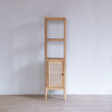 Wooden cabinet with a woven rattan door against a white wall