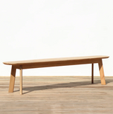 Outdoor wooden dining bench on a wooden floor against a plain wall
