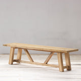 Wooden bench on a wooden floor with a plain white wall background