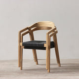 Outdoor rattan woven dining chair on a wooden floor against a plain wall