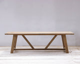 Wooden dining table on a light wooden floor and white wall background