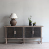 Reclaimed pine wood sideboard with decorative items in a room with a painting on the wall.