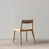 Wooden chair on a wooden floor with a plain gray wall background
