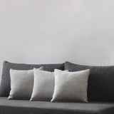 Decorative pillows on a greyish black sofa.