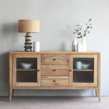 Wooden sideboard with glass doors and lamps in a room setting