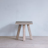 Reclaimed pine wood end table against a plain wall.