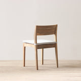 Outdoor chair with cushion on a wooden floor against a plain wall