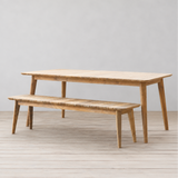 Outdoor wooden dining table and bench set on a wooden floor.