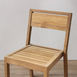 Wooden chair with slatted seat on a plain background