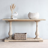 Monarch console table with decoration item on top and a wicker basket on the lower shelf.