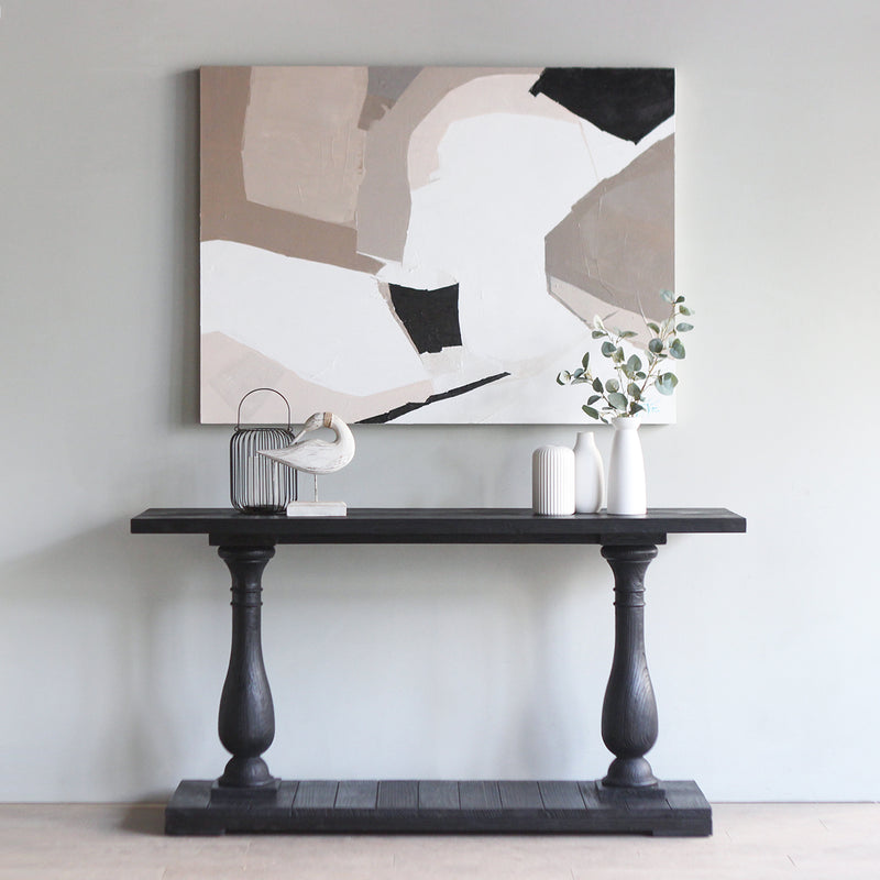 Monarch Console Table in black finish, with a modern abstract art hung above it. There are white vases and decoration items on it.