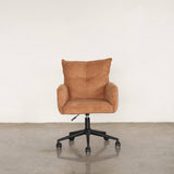 Upholstery chair with wheels on a stone floor against a grey wall.