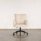 Beige office chair on a light stone floor and white wall background