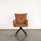 Orange uupholstered dining chair on a stone floor against a plain wall