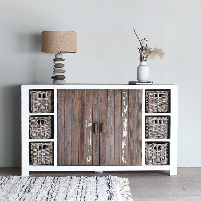 Aimann Sideboard (S) with pebbles lamp, white vase and books on top of it. There's a stripped rug in front of it.