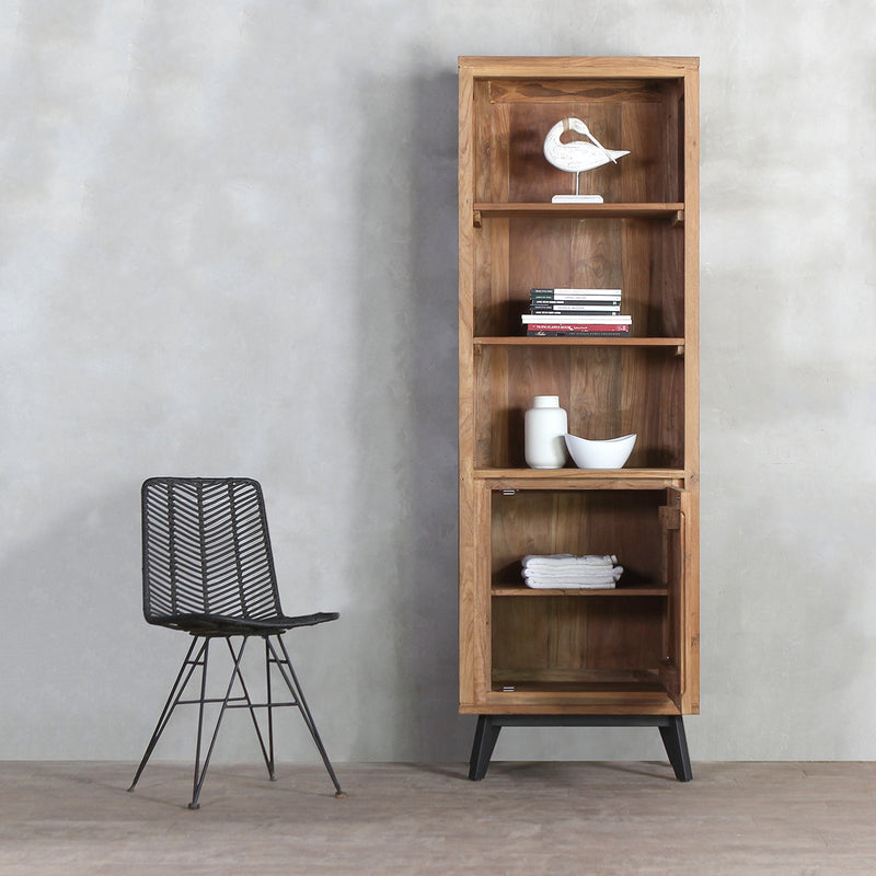 LINEA Open Bookcase with door opened next to a black rattan chair.