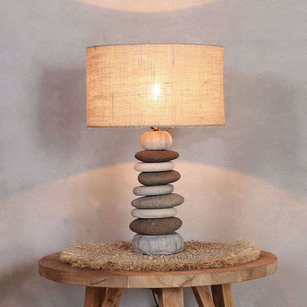 a turned-on Pebbles Lamp on top of Round Nesting Table (S).